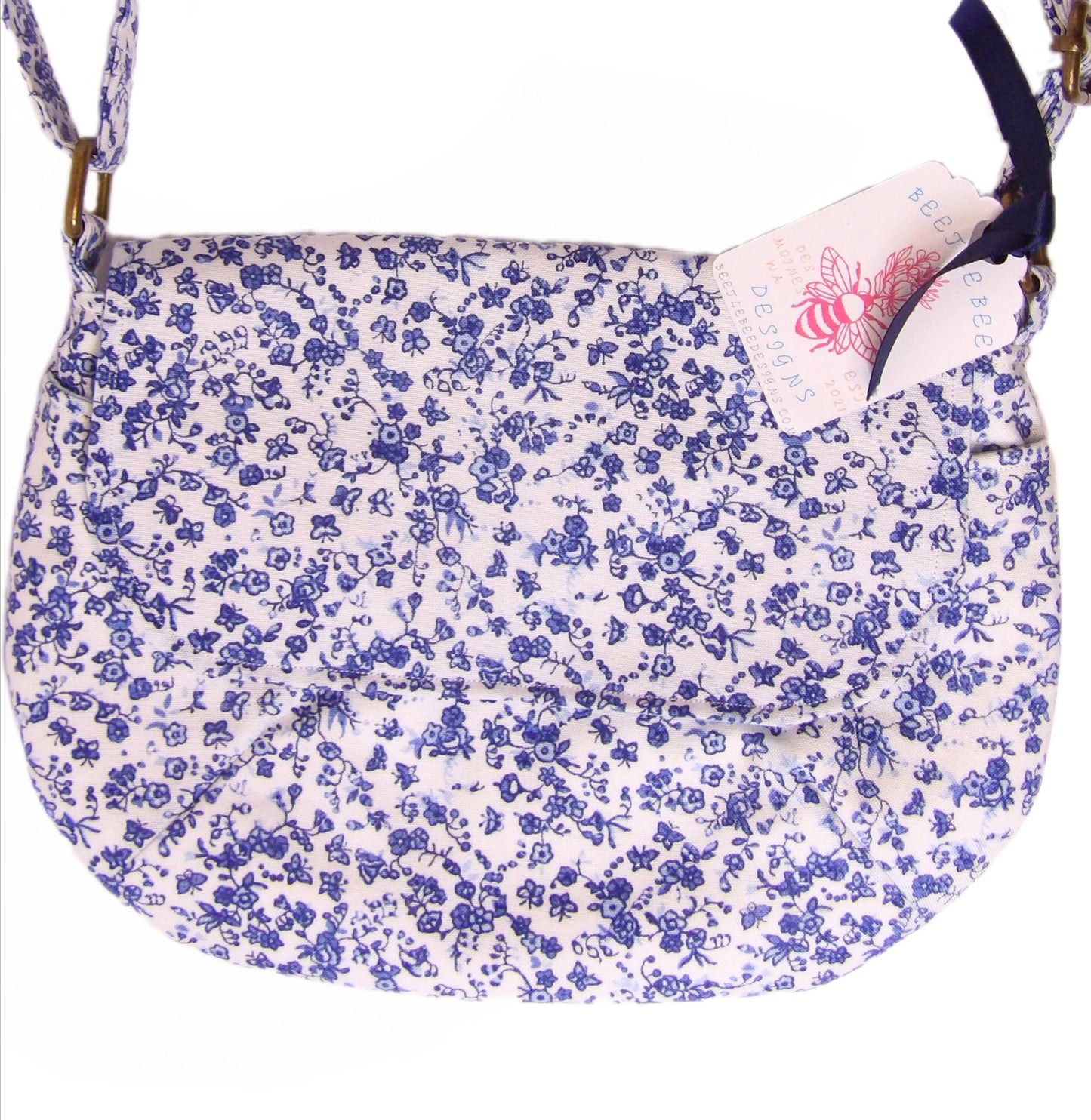 close up of blue and white floral fabric crossbody bag with whimsical butterfly motifs. Lightweight boho crossbody bag with enchanting flower fabric perfect for festivals and outings
