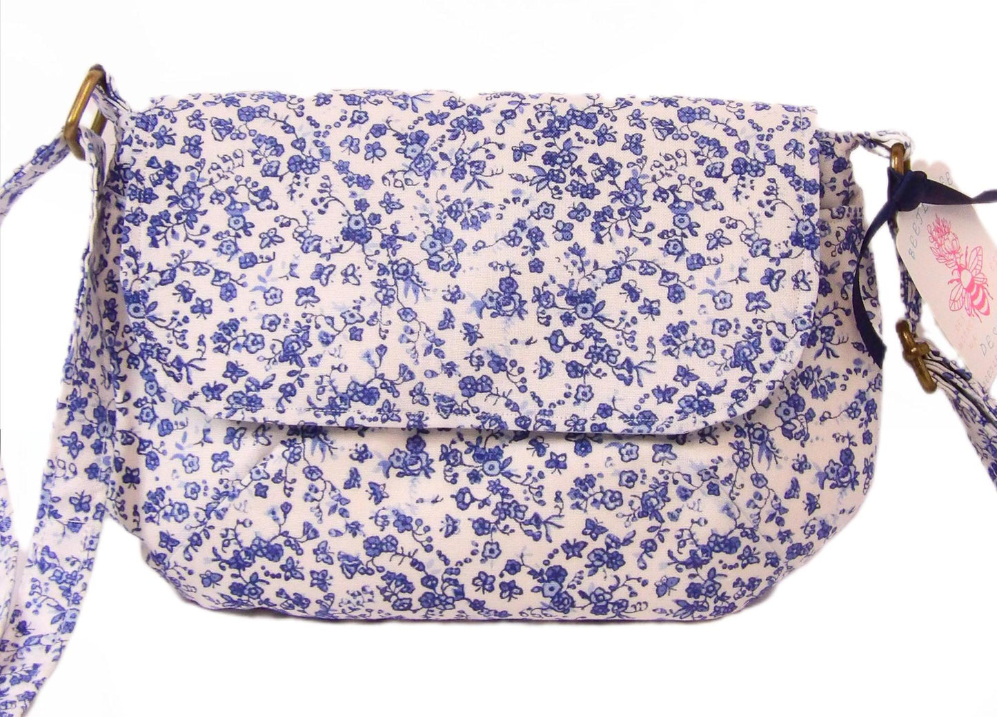 close up of blue and white floral fabric crossbody bag with whimsical butterfly motifs. Lightweight boho crossbody bag with enchanting flower fabric perfect for festivals and outings