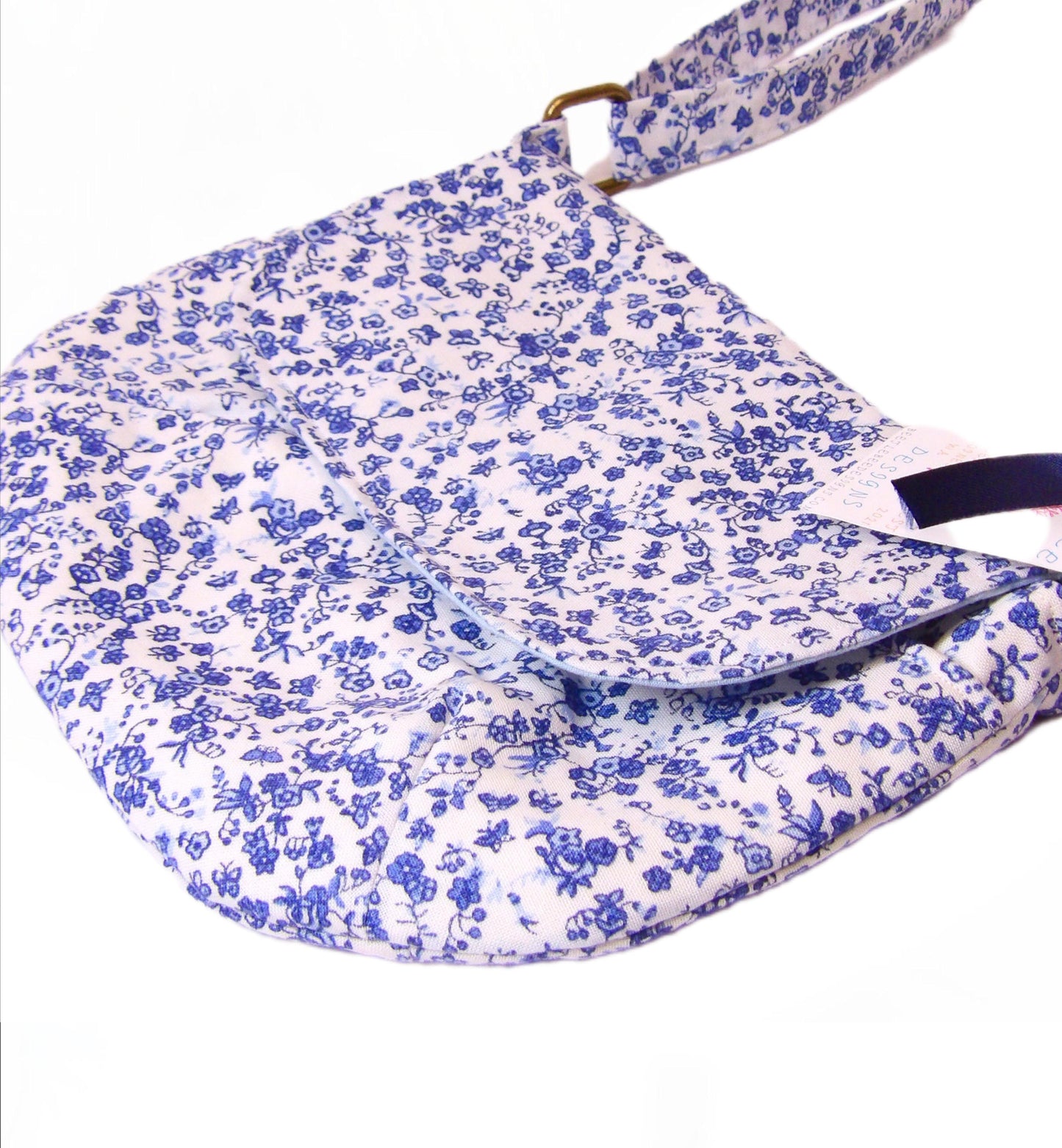 close up of blue and white floral fabric crossbody bag with whimsical butterfly motifs. Lightweight boho crossbody bag with enchanting flower fabric perfect for festivals and outings