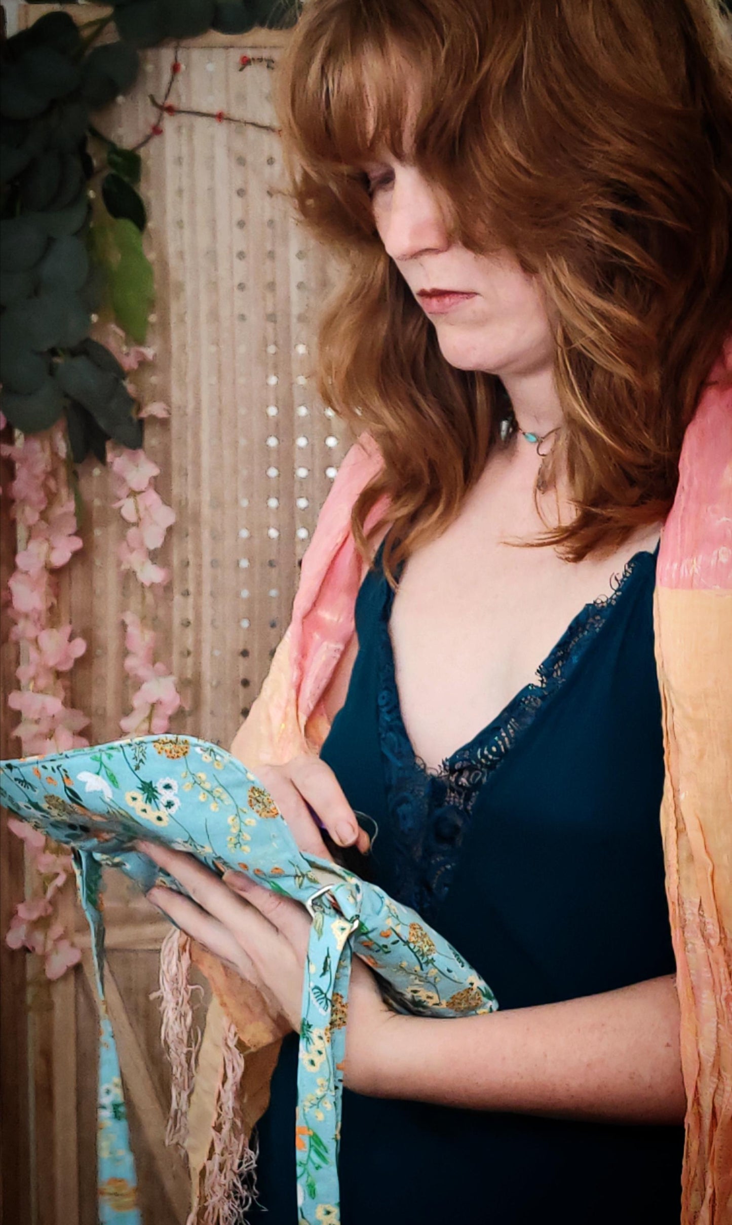 Model holding open whimsical floral fabric cotton crossbody purse. Bohemian style can be worn across the body or on the shoulder. Lightweight and perfect for festivals and day trips with adjustable strap and magnetic closure.