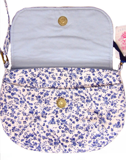 close up of open blue and white floral fabric crossbody bag with whimsical butterfly motifs. Lightweight boho crossbody bag with enchanting flower fabric perfect for festivals and outings