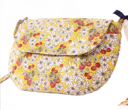 close up side view of a closed daisy fabric crossbody bag with bohemian style cherries and strawberries, lightweight crossbody purse with a whimsical floral print. Cotton fabric boho bag perfect for festivals and outdoor adventures