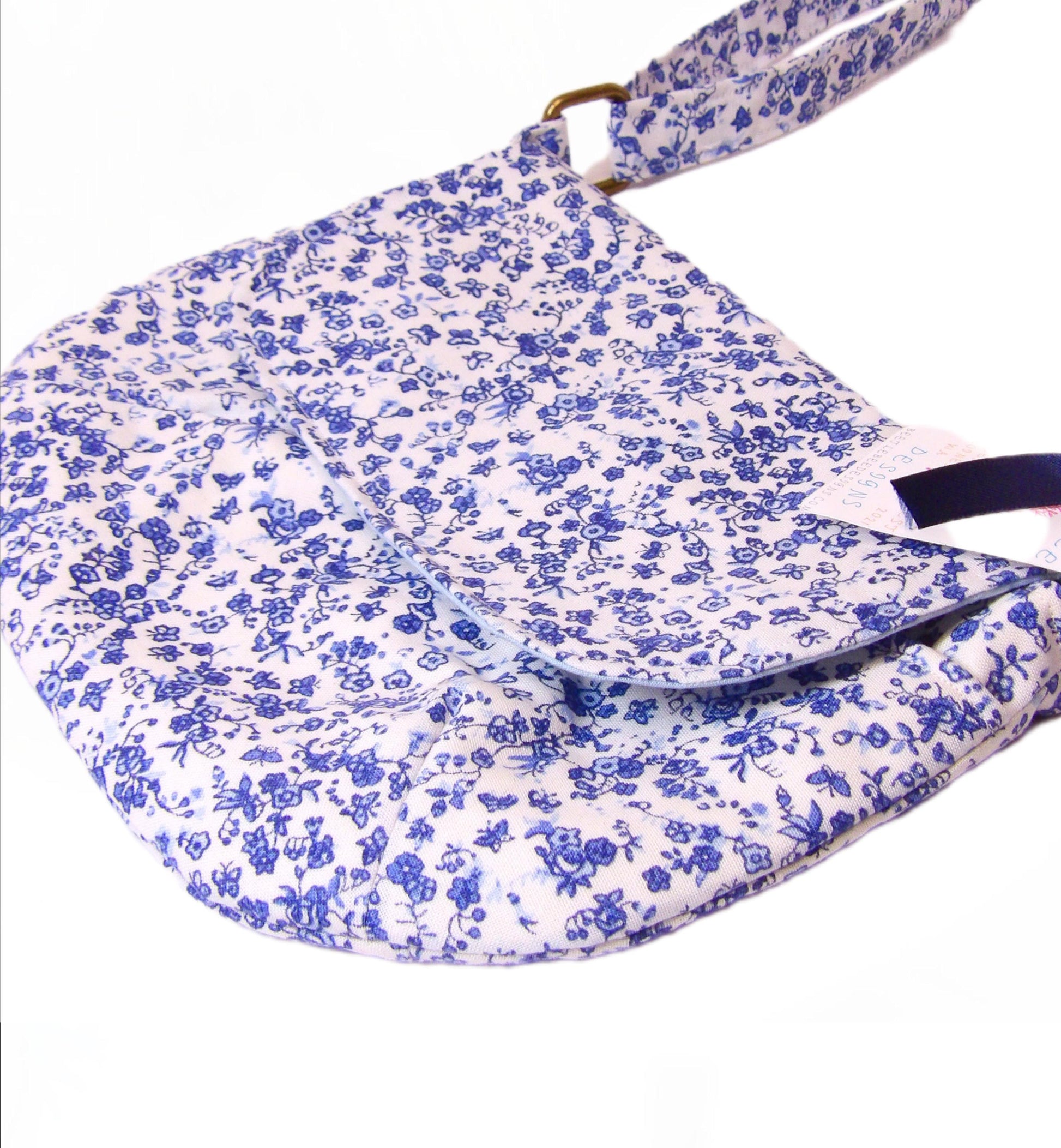 close up of blue and white floral fabric crossbody bag with whimsical butterfly motifs. Lightweight boho crossbody bag with enchanting flower fabric perfect for festivals and outings