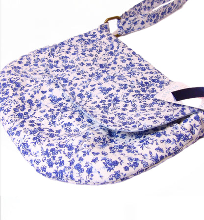 close up of blue and white floral fabric crossbody bag with whimsical butterfly motifs. Lightweight boho crossbody bag with enchanting flower fabric perfect for festivals and outings