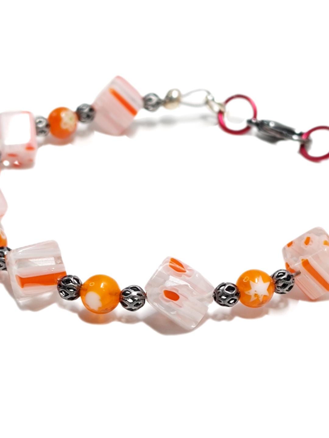 millefiori glass beaded bracelet made with floral mosaic beads and lace style rounds in a bohemian style. Colors are orange, white and grey.