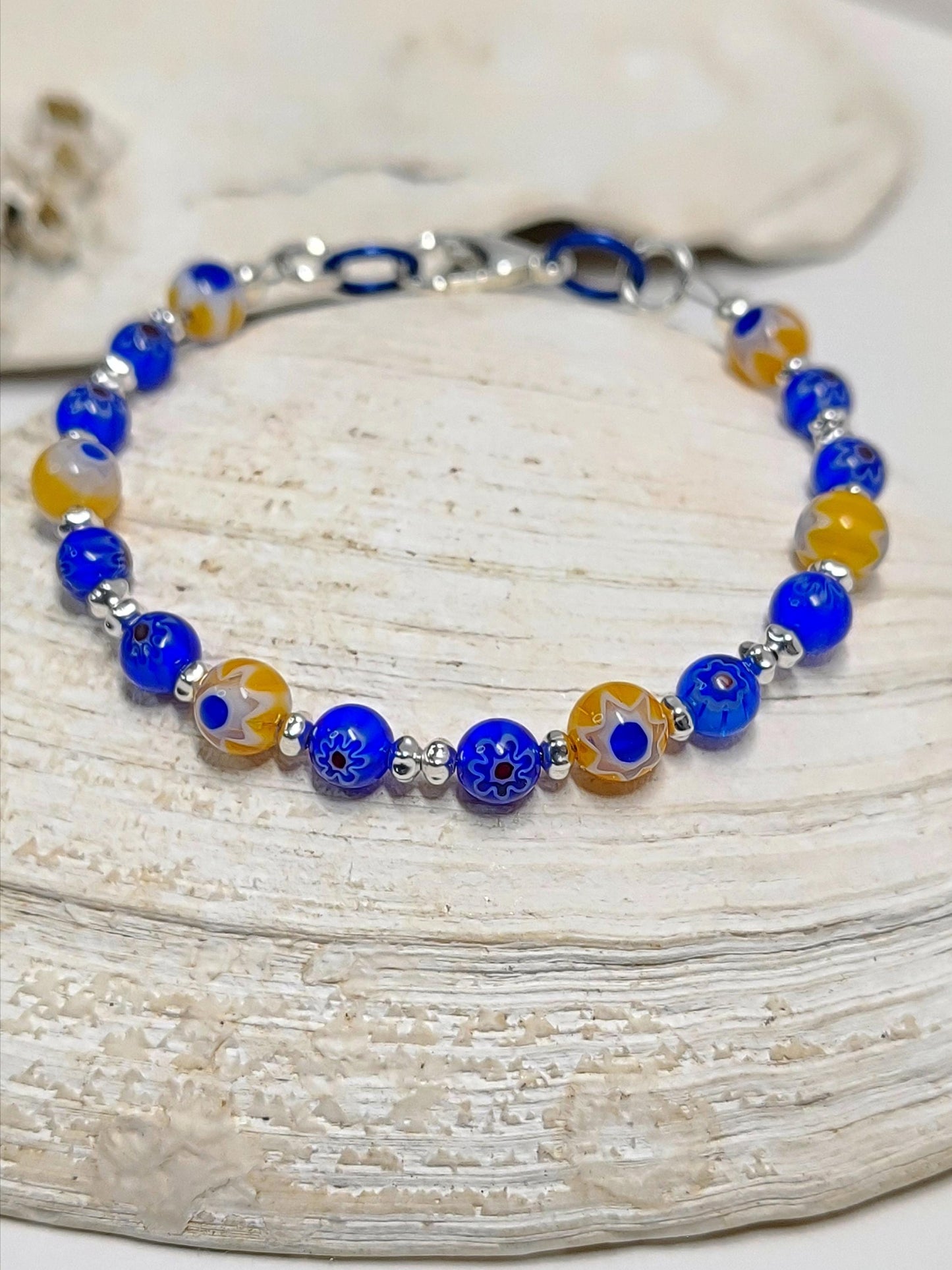 blue and yellow mosaic glass bracelet made with floral millefiori and star place spacer beads in a bohemian style.