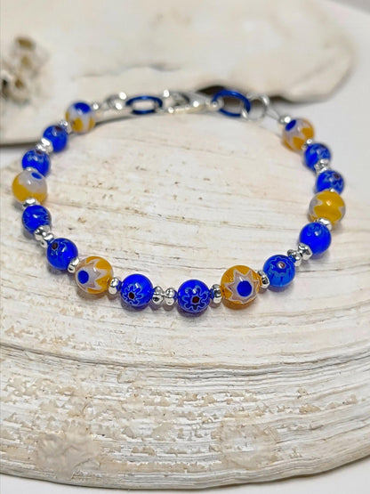 blue and yellow mosaic glass bracelet made with floral millefiori and star place spacer beads in a bohemian style.