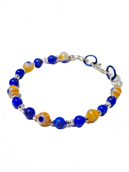 blue and yellow mosaic glass bracelet made with floral millefiori and star place spacer beads in a bohemian style.