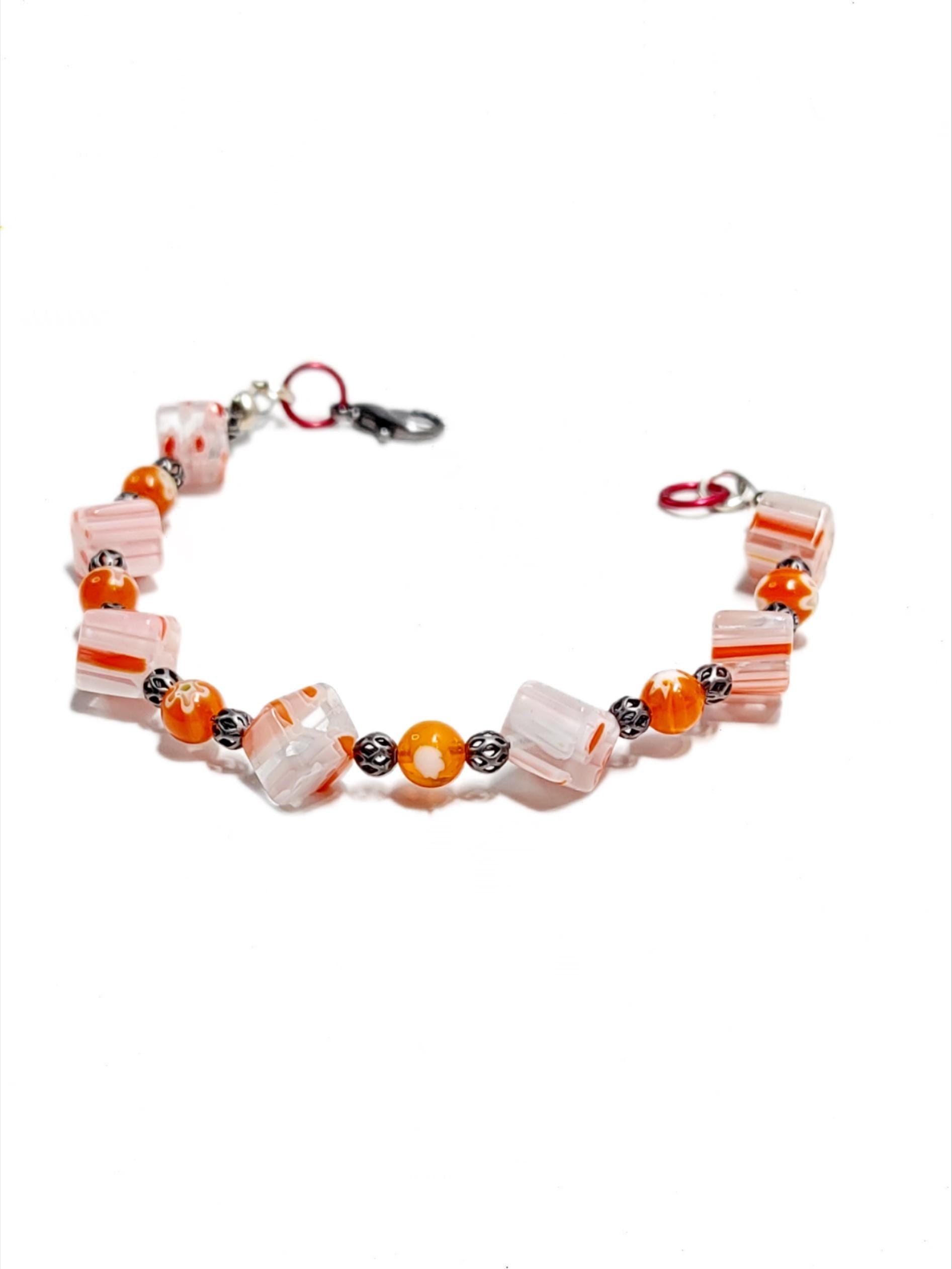 millefiori glass beaded bracelet made with floral mosaic beads and lace style rounds in a bohemian style. Colors are orange, white and grey.