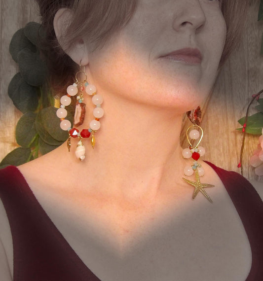 Model wearing asymmetrical earrings with ocean sea life charms, agate slices, white jade, amazonite, carnelian and brass findings. Hand made in USA with ethical gemstones in a boho fashion