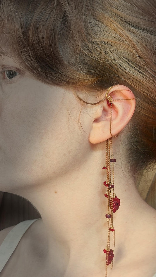 Flower Ear Cuff wrap around earring with red czech glass seed beads. Ear wrap frame sits behind the ear and has chain accents that adorn the top half of the ear along with cascading chains that come from behind the ear. Chains are adorned with hand wrapped czech glass beads in rich red tones. Beads include grape and flower motifs for a rustic, bohemian aura