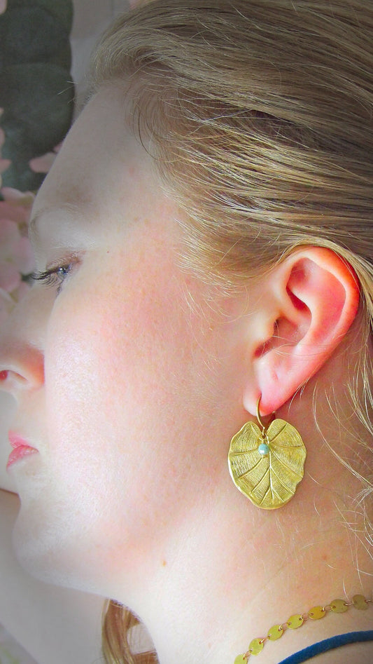 emerald earrings with large leaf charm. boho earrings with leaf charm and natural emerald. raw crystal emerald earrings